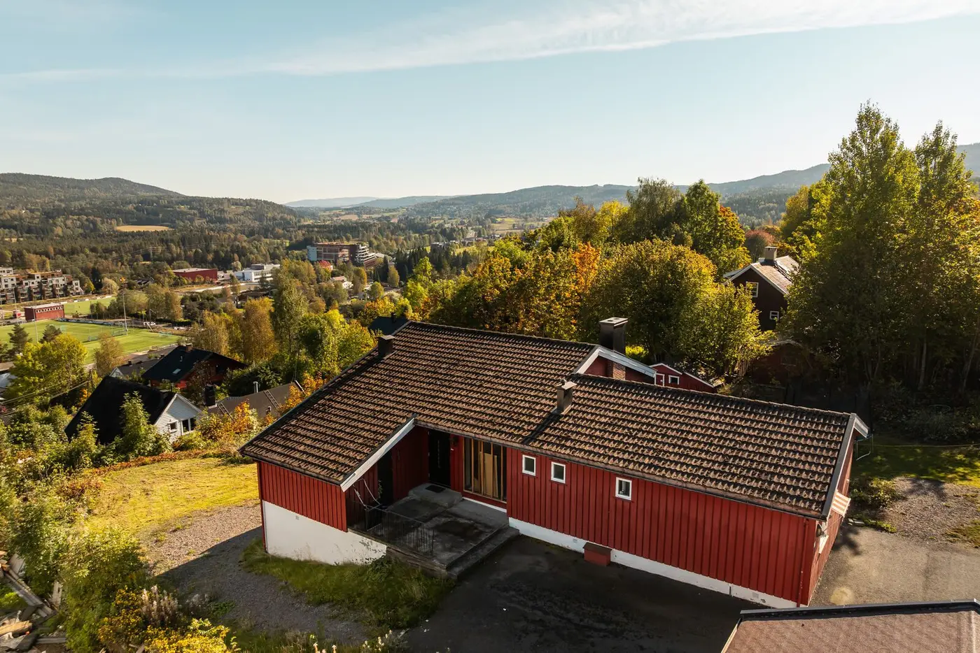 Hoveddelen har et fint inngangsparti med asfaltert adkomst, støpt velkomstterrasse på ca. 14 kvm og tilliggende utebod.