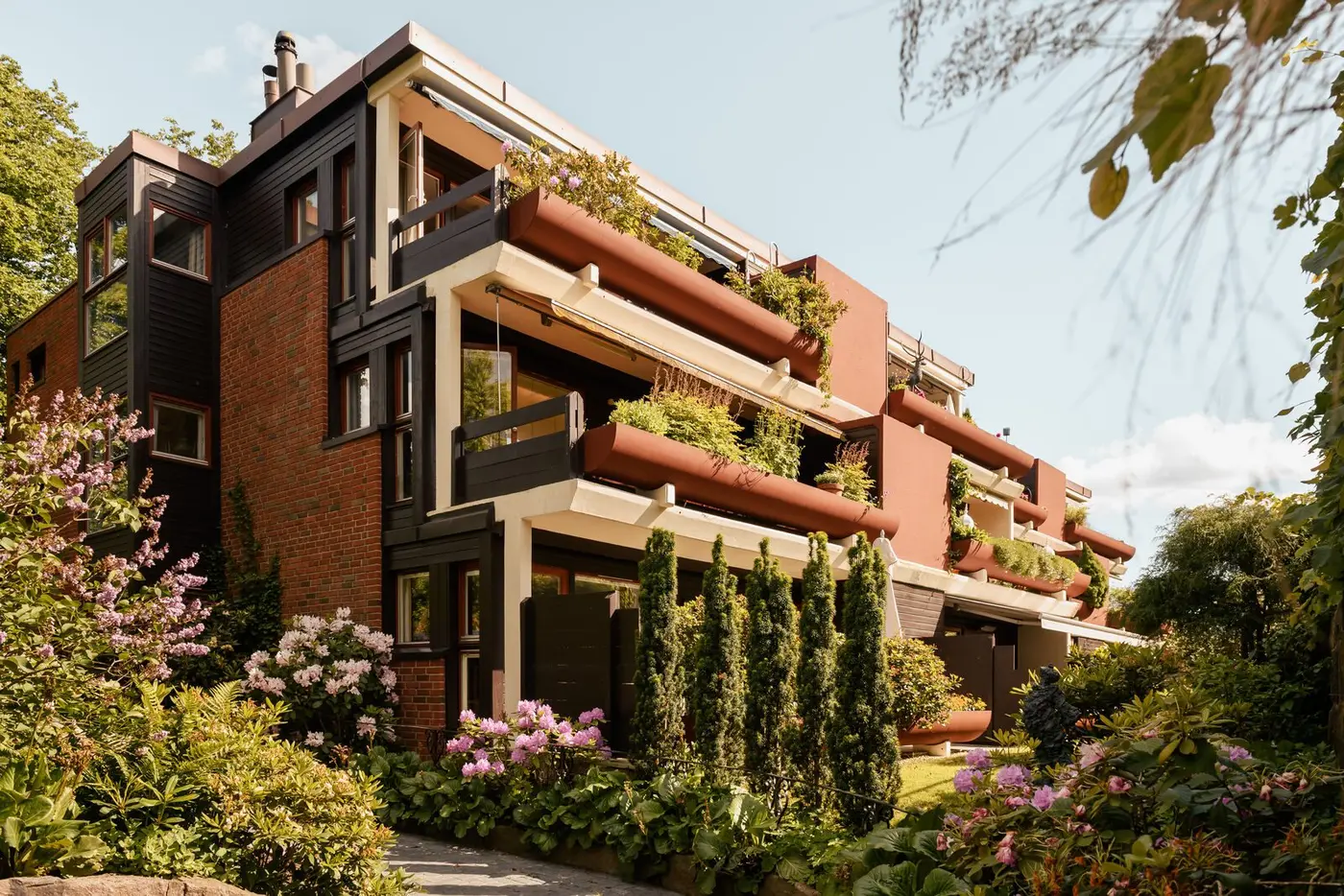 Vakker teglstensfasade, frodige omgivelser og karakteristisk arkitektur.