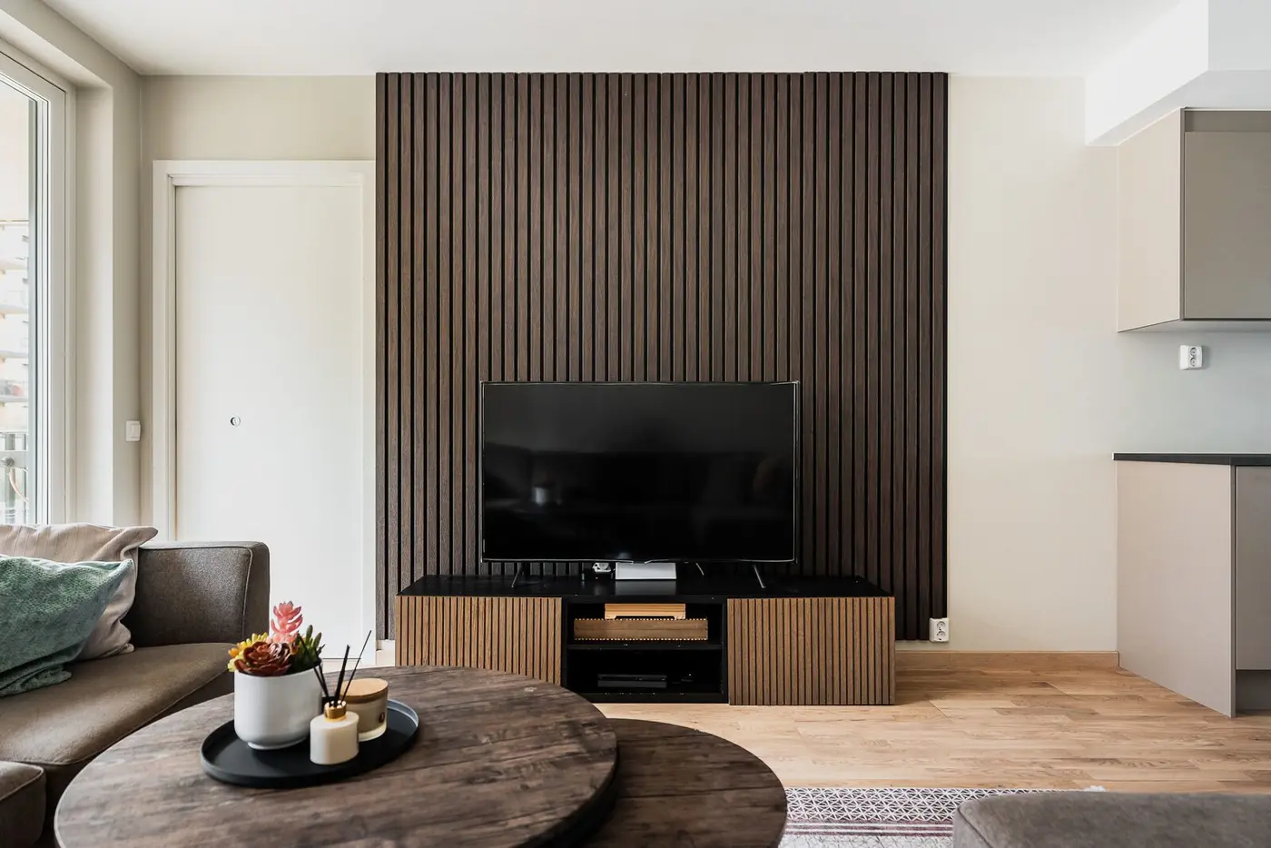 Stuen har en stilren spilevegg som definerer sonen for TV-kroken.